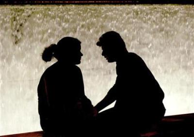 A couple sits in front of a fountain in Athens' Syntagma square